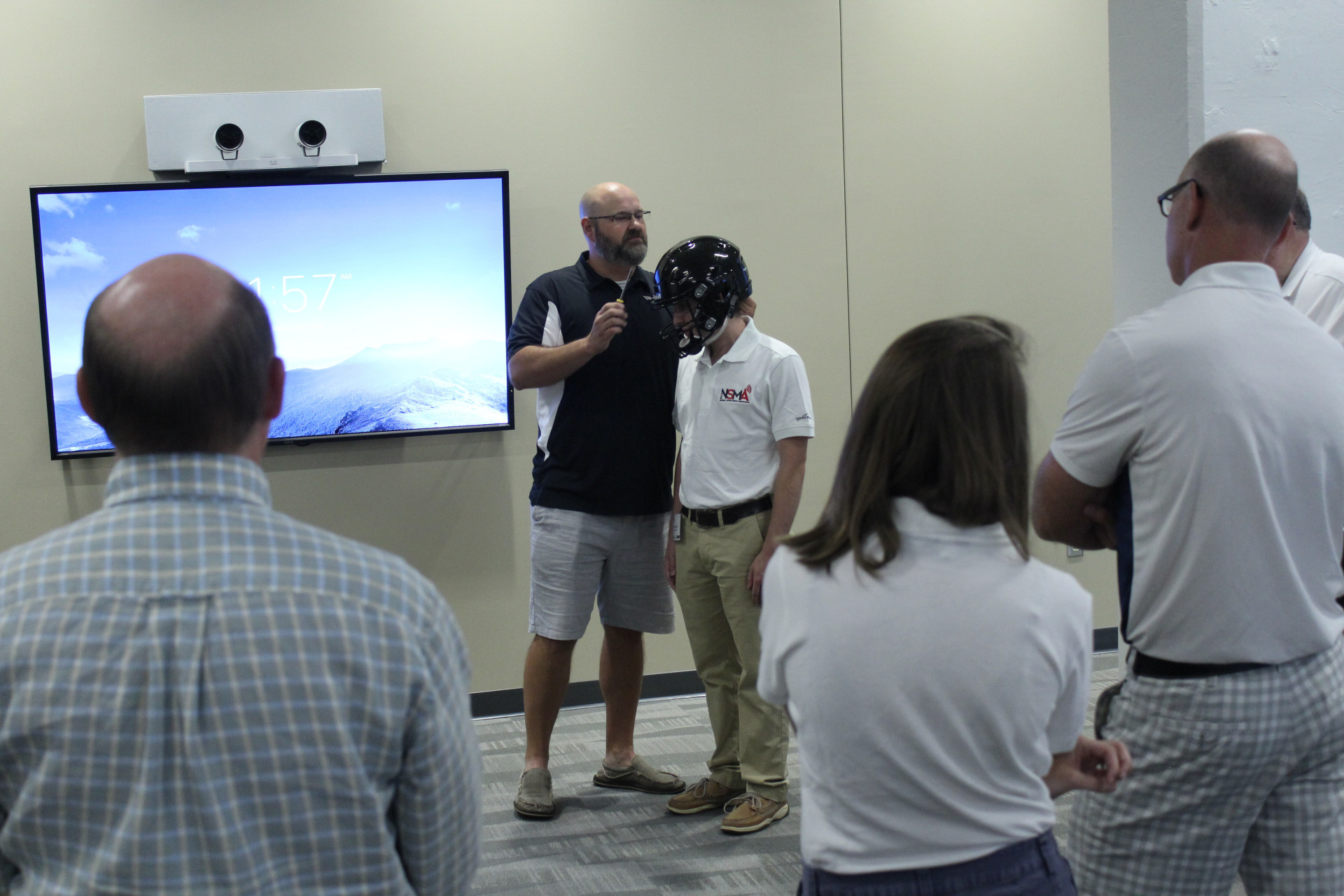 Wake Forest equipment manager Brian Daniels demonstrates proper helmet fitting on Wingate University rising senior Brendan Shriver (Daniel Coston Photo)